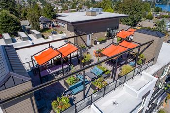 A patio with orange awnings and a glass railing  at Spyglass Hill Apartments, Bremerton, 98337